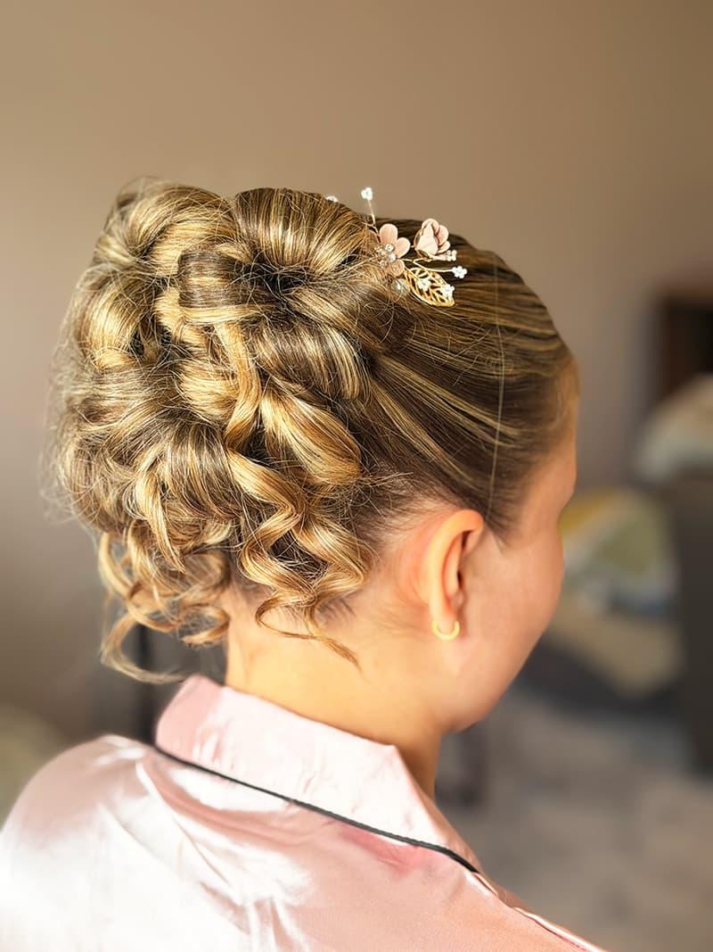 Curly bridal updo with floral hair pin styled in Hampshire
