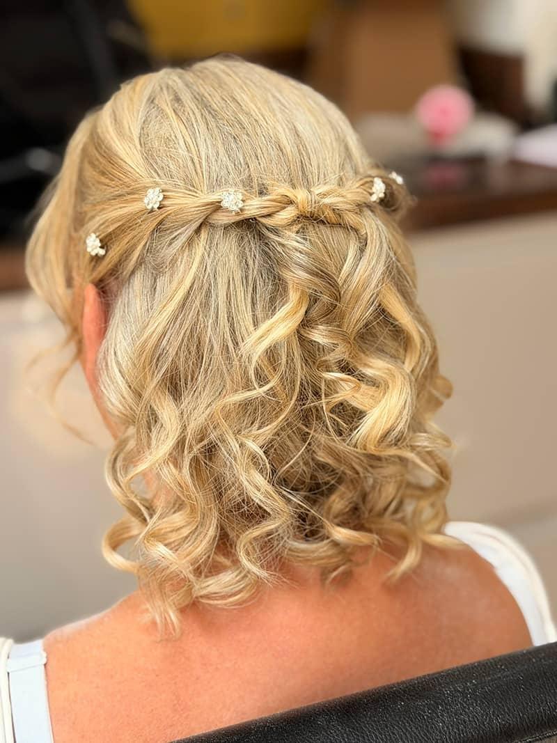 Blonde half-up bridal hair with twisted crown and pearl pins
